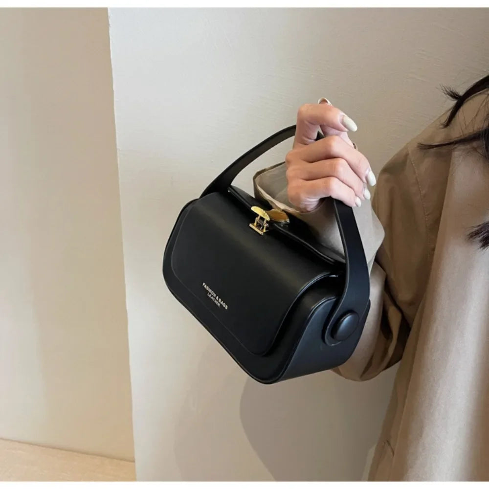 Elegant Black Box Handbag with Gold Clasp and Adjustable Strap